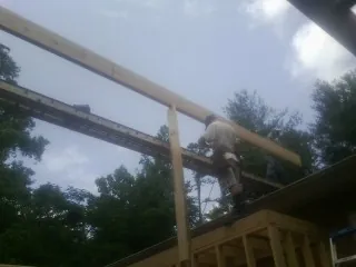 Carpenter setting a ridge beam over a new addition frame — Ice Dam Removal by Roofing Brothers in Fairmont