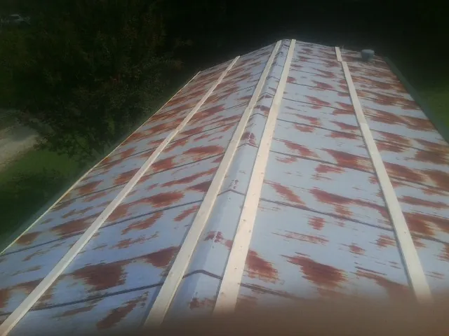 Rusted metal roof panels with new wood purlins before replacement — Storm Damage Roof Repair in Fairmont by Roofing Brothers