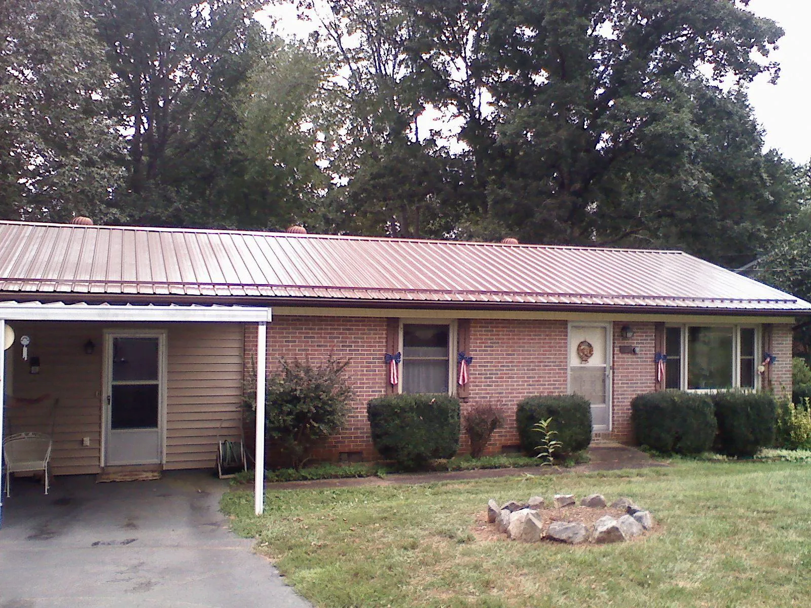 Bronze metal roof and carport on a brick ranch home — Roof Repair work by our crew in Fairmont